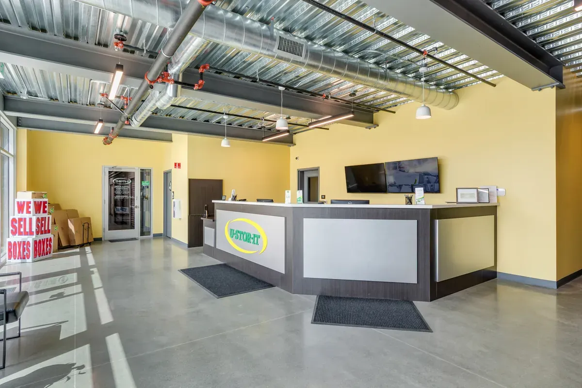 Modern U-Stor-It rental office lobby featuring a wide customer service desk and exposed industrial ceiling.
